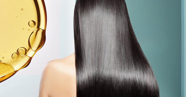 Close-up of long, shiny black hair nourished by collagen with golden oil texture background – Unwritten Hair blog on collagen benefits for stronger, healthier hair.