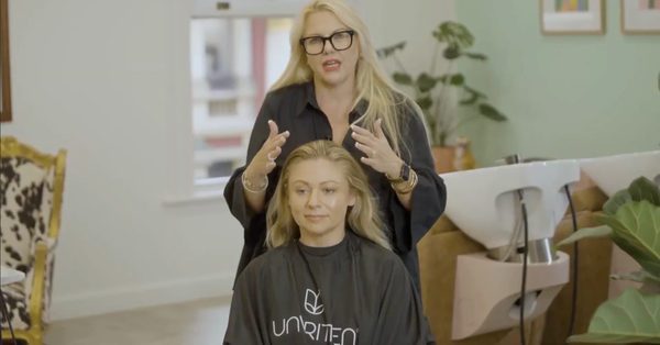Professional hair stylist explaining haircut timing to a client in a salon.