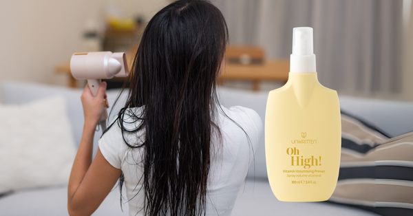 Unwritten Hair Oh High! Vitamin Volumising Primer with woman blow drying wet hair at home – lightweight heat protection and volume boost.